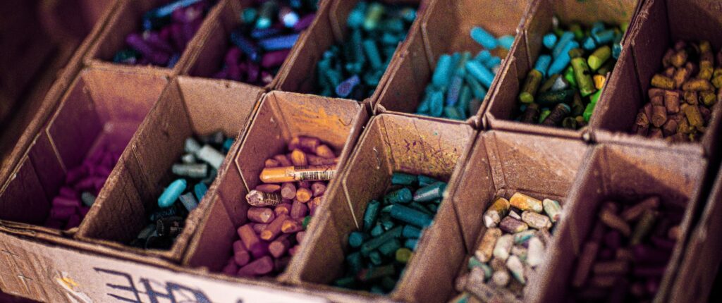 Nahaufnahme einer Kiste mit Kreidestifen, die nach Farbe sortiert sind